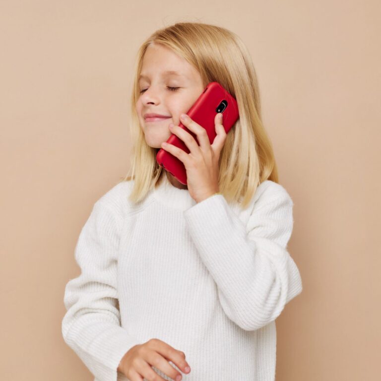 Mädchen hält rotes Handy in der Hand